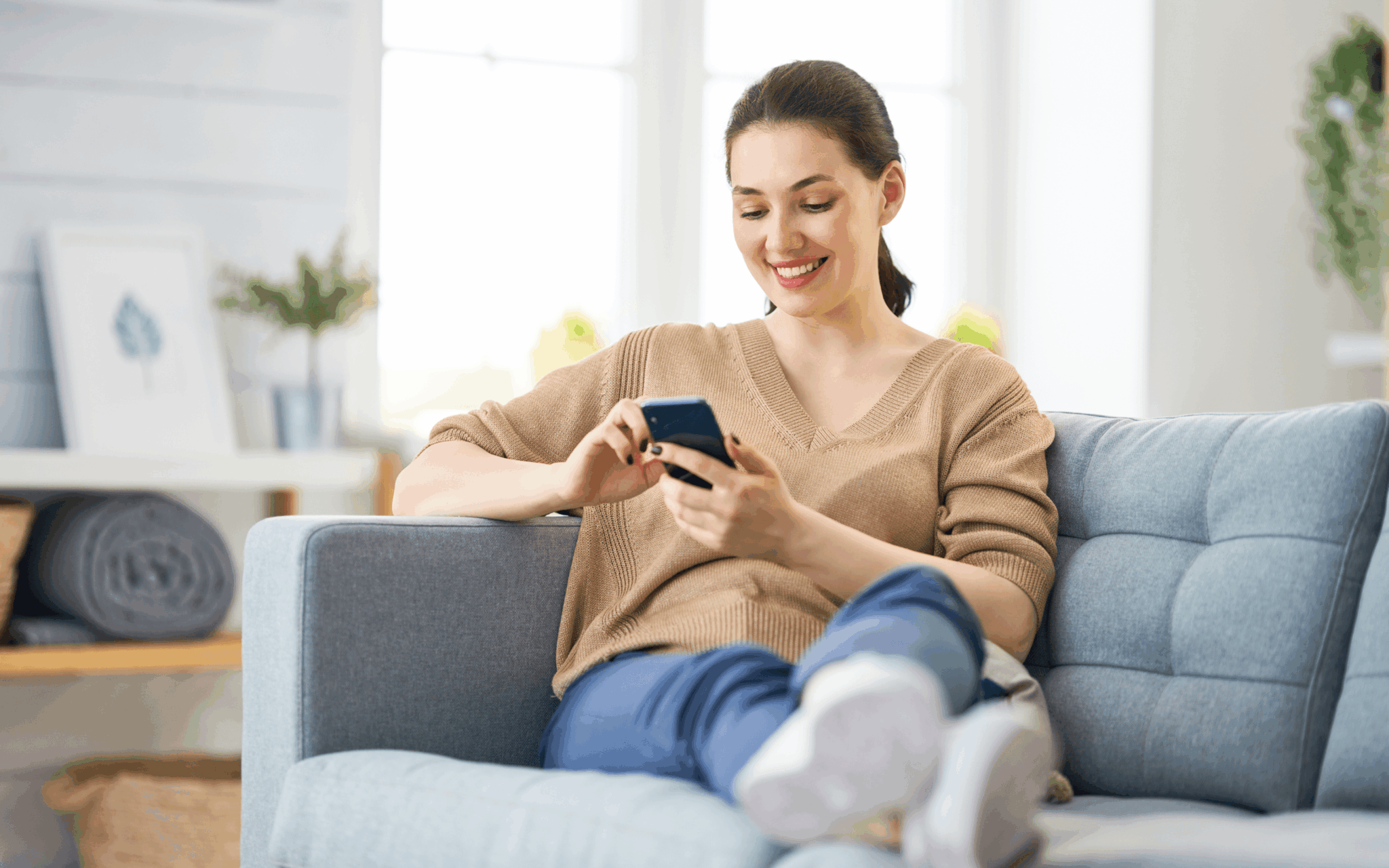 Smiling woman relaxing in a freshly cleaned living room while booking Next Day Cleaning services on her smartphone